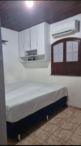 a bedroom with a bed in a room with a kitchen at Casa família COP30 in Belém