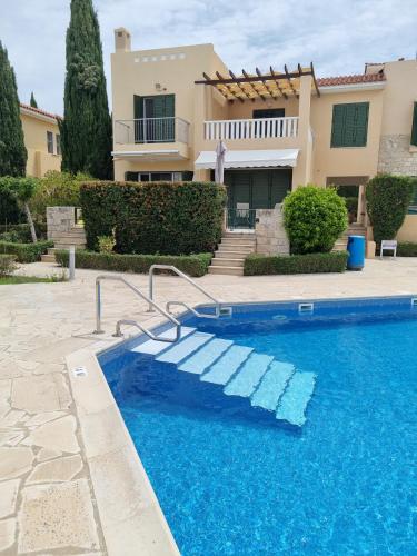 a villa with a swimming pool in front of a house at Cyprus Townhouse Pool Patio Aircon Free Parking in Polis Chrysochous