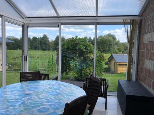 une véranda avec une table et des chaises dans l'établissement Gîte Sidney, à Saint-James