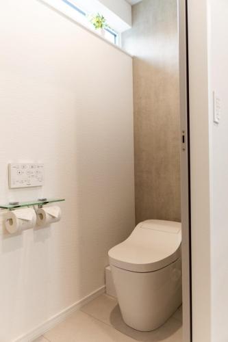 a small bathroom with a toilet and a window at comma, shunko in Asahikawa