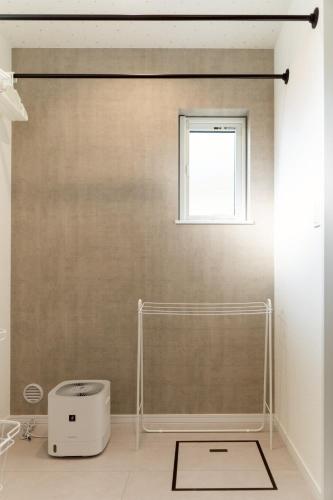 a bathroom with a shower with a window and a sink at comma, shunko in Asahikawa