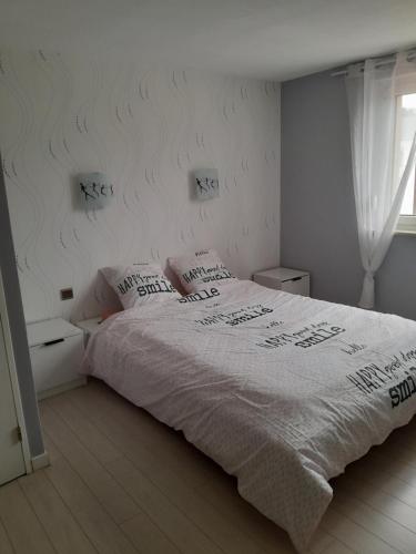 une chambre avec un grand lit avec des draps blancs dans l'établissement Christiane and Danys cottage Nice apartment for 4 people, à Munster