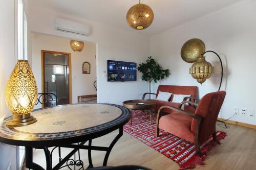 a living room with a table and a dining room at Quinta do Canal in Vila Nova de Milfontes