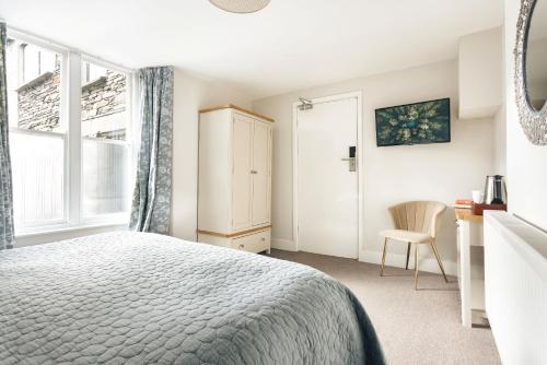 Un dormitorio con una cama y una ventana y una silla. en Finest Retreats - Kelsick Villa Guest House - Gummers How, en Ambleside