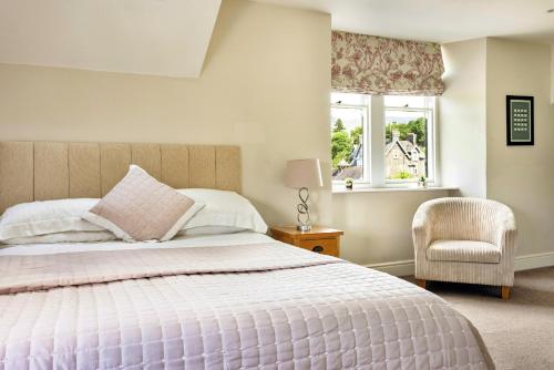 a bedroom with a bed and a chair and a window at Finest Retreats - Kelsick Villa Guest House - Helvellyn in Ambleside