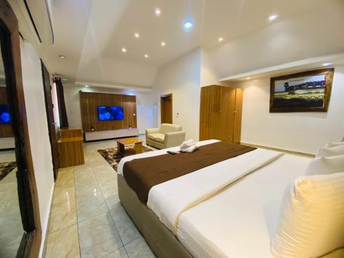a hotel room with a large bed and a chair at Presken Hotels @ Victoria Island in Apese