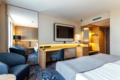 a hotel room with a bed and a desk and a tv at Airport Hotel Okęcie in Warsaw