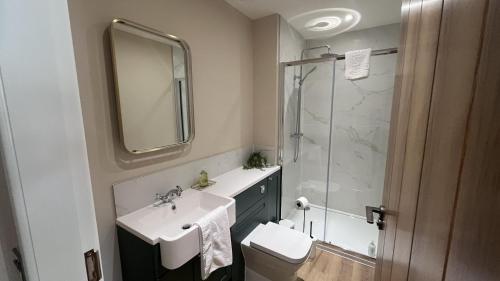a white bathroom with a sink and a shower at Easter Kincaple Garden Cottage in Guard Bridge
