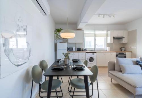 a kitchen and living room with a table and chairs at The Seven - One Bedroom Apartment in Paralimni