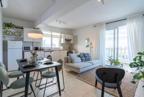 a kitchen and living room with a table and chairs at The Seven - One Bedroom Apartment in Paralimni