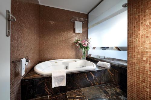 a bath tub in a bathroom with a mirror at Eurostars Thalia in Prague