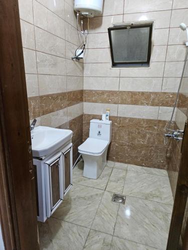 a bathroom with a toilet and a sink and a mirror at Rest & Relax Studio in Ajloun