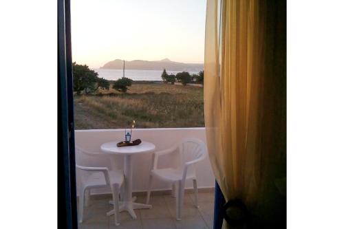 a table and chairs with a candle on a balcony at Vigles in Adamas