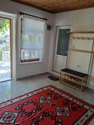 a living room with a red rug on the floor at Sunny Guest House in Gjirokastër