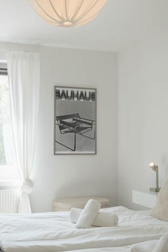 a bedroom with a white bed and a picture on the wall at Fewo Fritz am Bauhausmuseum in Dessau