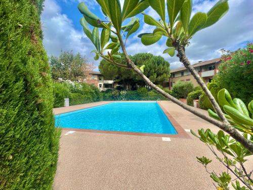 een zwembad in een tuin met bomen bij " Côté Parc " Cité de l'espace - Entrée autonome in Toulouse