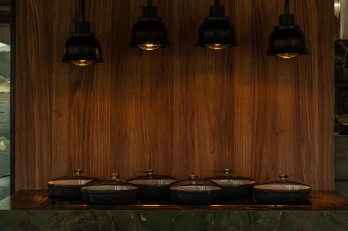 a group of four bowls on a table with lights at Eleonas Boutique Hotel & Spa - Adults Only in Ialyssos