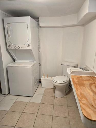a bathroom with a toilet and a tv on the wall at Midtown Guest House in Mobile