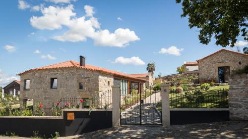 a stone house with a gate in front of it at Valados do Outeiro - Casas de Campo in Valença