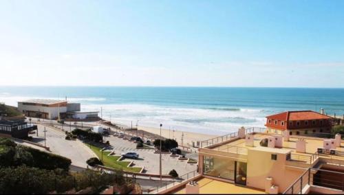 a view of a beach and the ocean from a building at Heart Stone by the Sea in Lourinhã