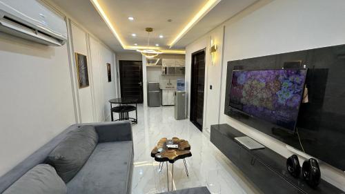 a living room with a couch and a flat screen tv at Luxury Private Top Floor Apartment in Heart of Bahria Town in Lahore