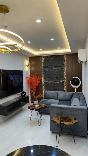 a living room with a blue couch and a tv at Luxury Private Top Floor Apartment in Heart of Bahria Town in Lahore