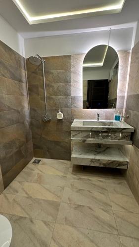 a bathroom with a sink and a mirror at Luxury Private Top Floor Apartment in Heart of Bahria Town in Lahore