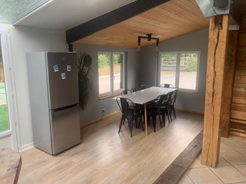 une salle à manger avec une table et un réfrigérateur dans l'établissement Maison de vacances, à Hanvec