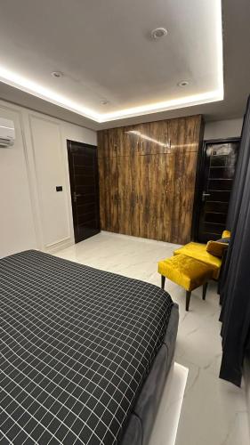 a bedroom with a bed and a yellow bench at Luxury Private Top Floor Apartment in Heart of Bahria Town in Lahore