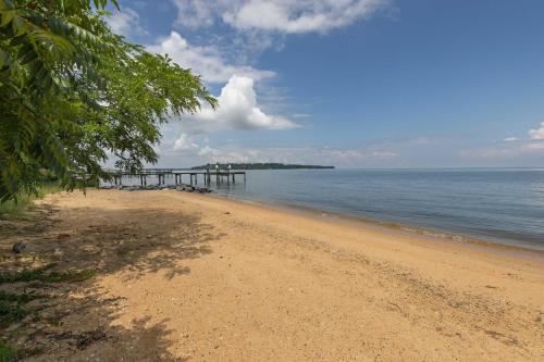 a sandy beach with a pier in the water at New The Pool Loft at Poplar Hill in Annapolis