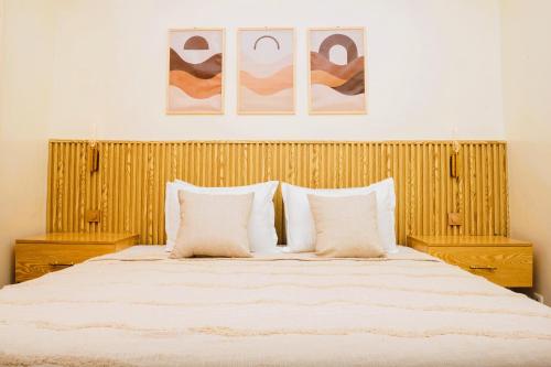 a bedroom with a large bed with two pillows at Senlodge in Dakar