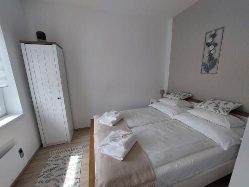 a bedroom with a large bed with white sheets at Három Testvér Apartman in Siófok