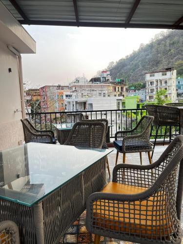 a group of tables and chairs on a balcony at Hotel Buransh inn Ghugtani secret Waterfall Road Tapovan Rishikesh in Rishīkesh