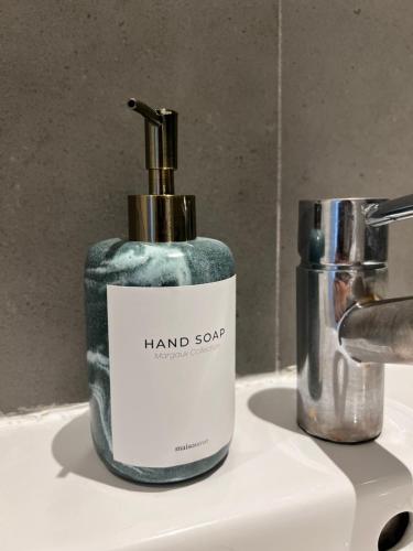 a bottle of hand soap sitting on a bathroom sink at Luxury property with stunning views of Canary Warf in London