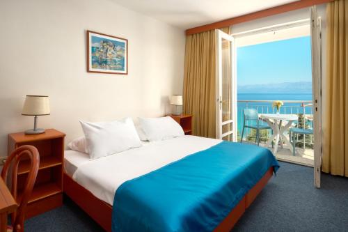 a hotel room with a bed and a balcony at Hotel Faraon in Trpanj