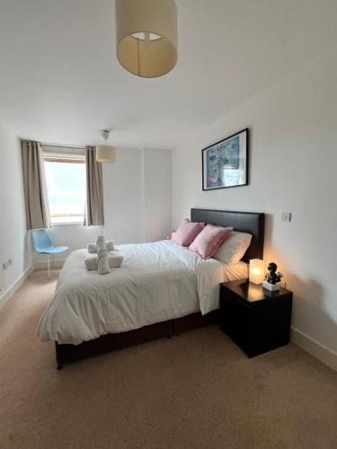 a bedroom with a large bed with pink pillows at Luxury property with stunning views of Canary Warf in London