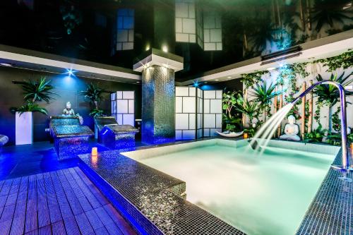 a heated pool with a water slide in a building at Grand Hotel Don Gregorio in Salamanca