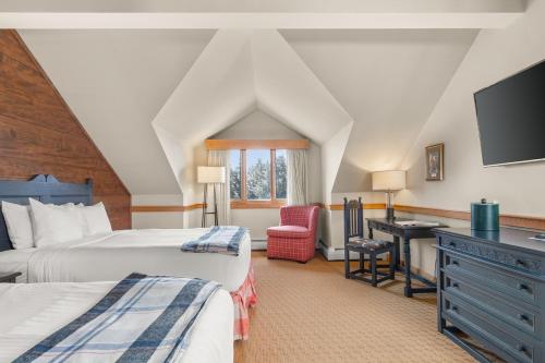 a bedroom with two beds and a desk with a television at von Trapp Family Lodge & Resort in Stowe