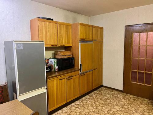 a kitchen with wooden cabinets and a refrigerator at WG in Homberg Efze, Monteurzimmer, 2 Erwachsene, 1 Doppelzimmer Nr 1 in Mörshausen