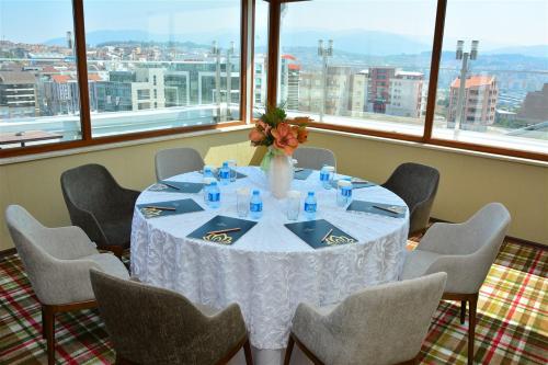 a table with chairs and a vase of flowers on it at Adranos Hotel in Bursa