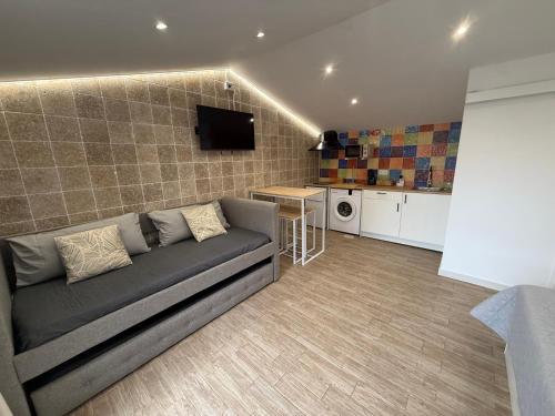 a living room with a couch and a kitchen at Hotel Rural Los Abriles in El Toro