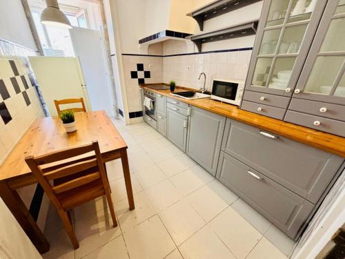 a large kitchen with a wooden table and a counter at Luxury rooms in Central Lisbon next station in Lisbon