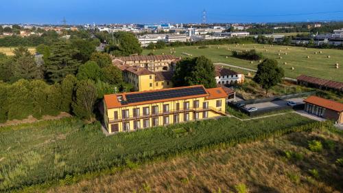 an aerial view of a yellow building on a field at Grow Green in Caponago