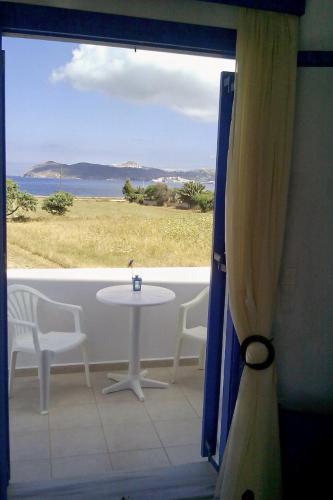 a table and chairs in a room with a window at Vigles in Adamas