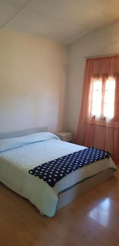 a bedroom with a bed with a blue and white blanket at Camping Europa in Capoliveri