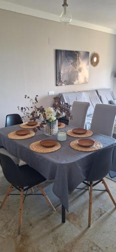 a dining room table with a blue tablecloth and chairs at Apartamento con jardin in La Línea de la Concepción