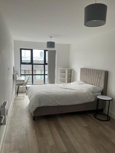 a bedroom with a bed and a table and a desk at Birmingham City Center View in Birmingham