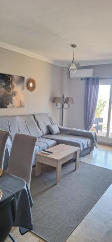 a living room with a couch and a table at Apartamento con jardin in La Línea de la Concepción