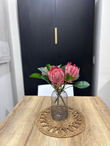 a vase of pink flowers sitting on a table at Inside Out Bliss in Paarl