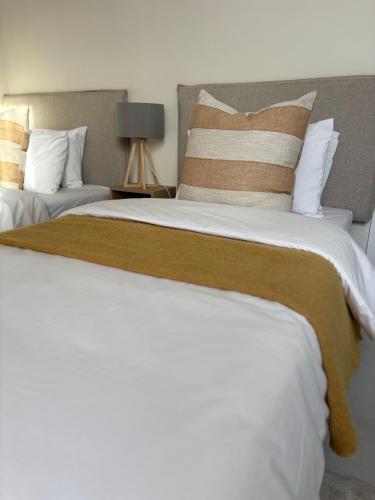 a bedroom with two large beds with pillows at Inside Out Bliss in Paarl